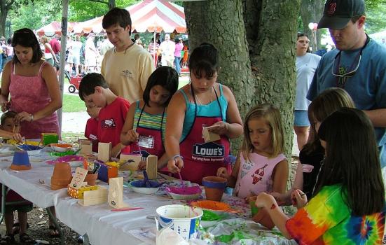 A group of children at an arts and crafts table, they are painting