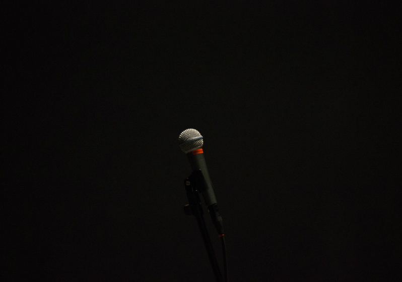 A black background with a microphone