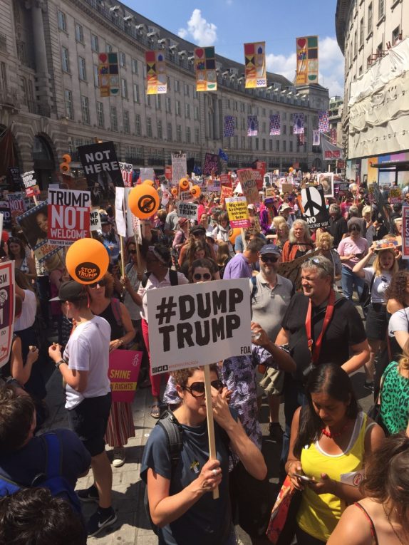 A protest in central London, one sign reads '#dumptrump