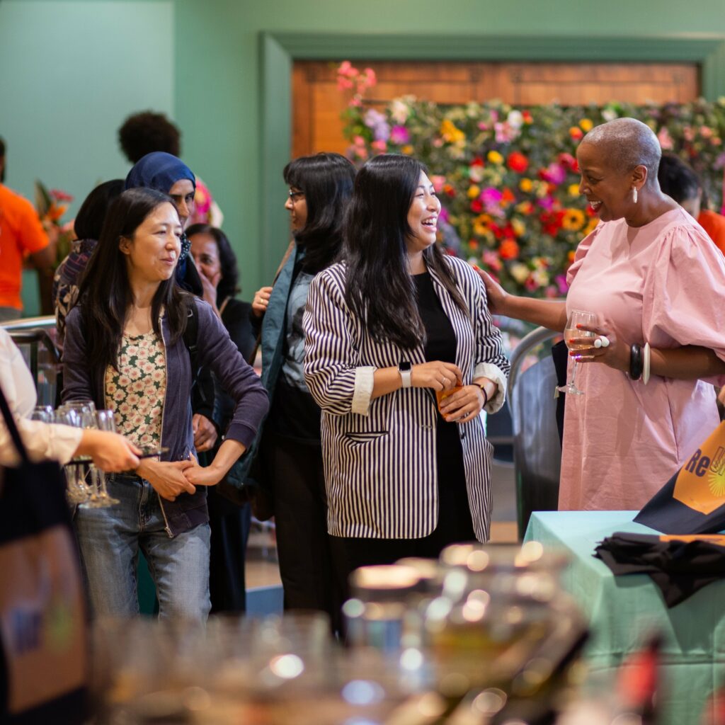 A group of people chatting at the Re-UP! launch