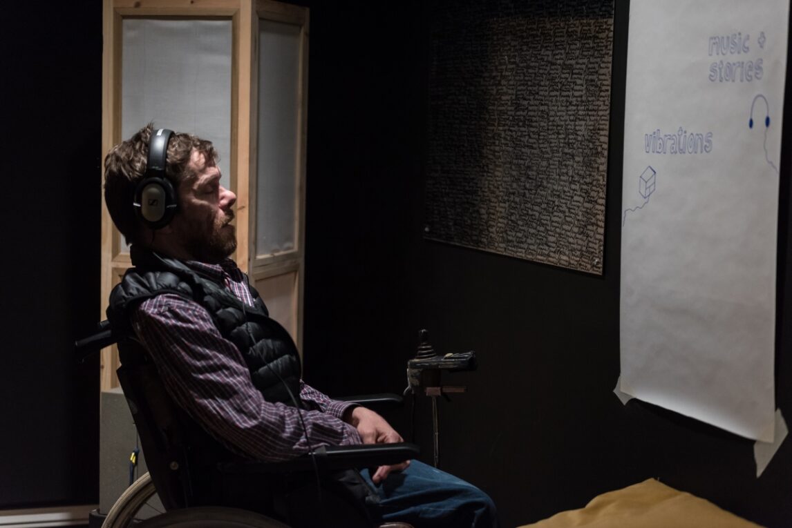 A person in wheelchair in a recording studio, they are wearing headphones