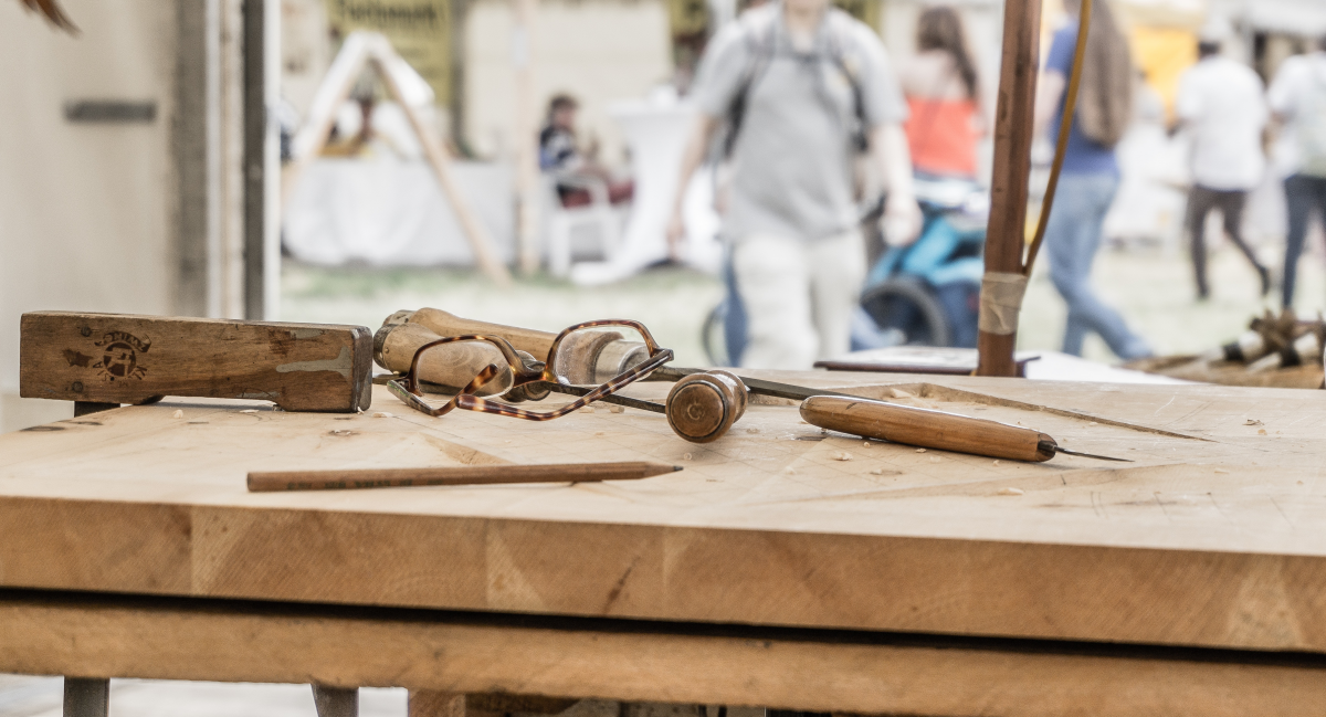 Wooden tools and a pair of glasses on a wooden tool bench