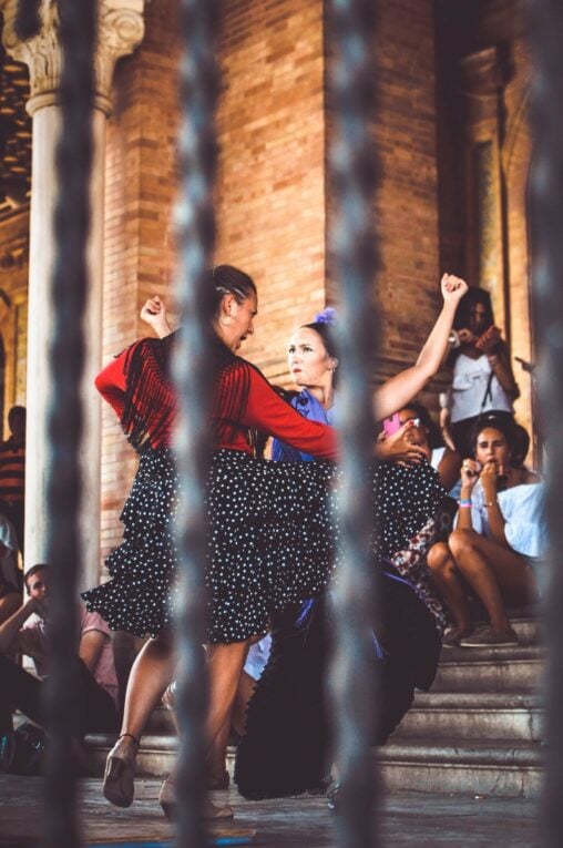 Two flamenco dancers dancing on the steps of a building