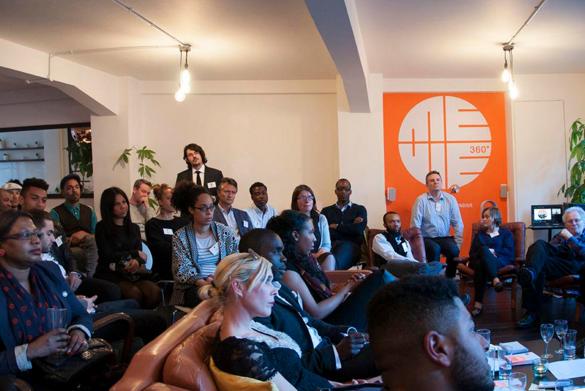 A group of people, some stood, some sat, listening to a conversation