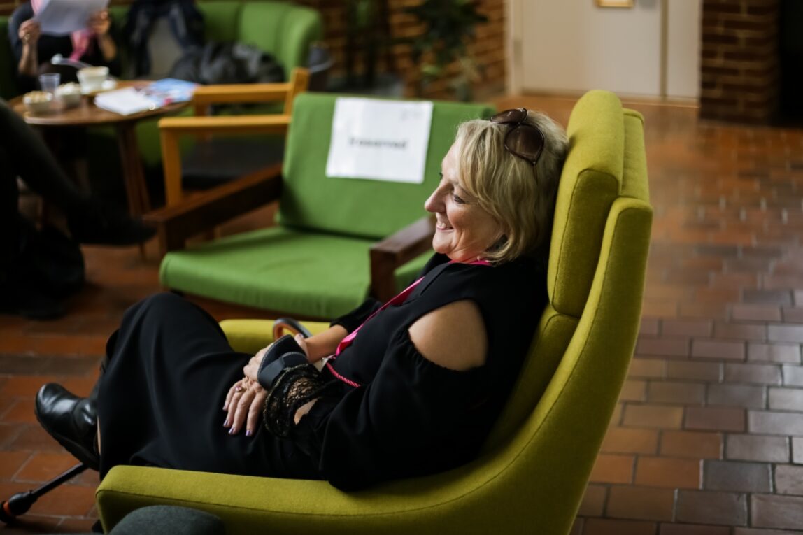 Sarah Pickthall sitting in a green armchair