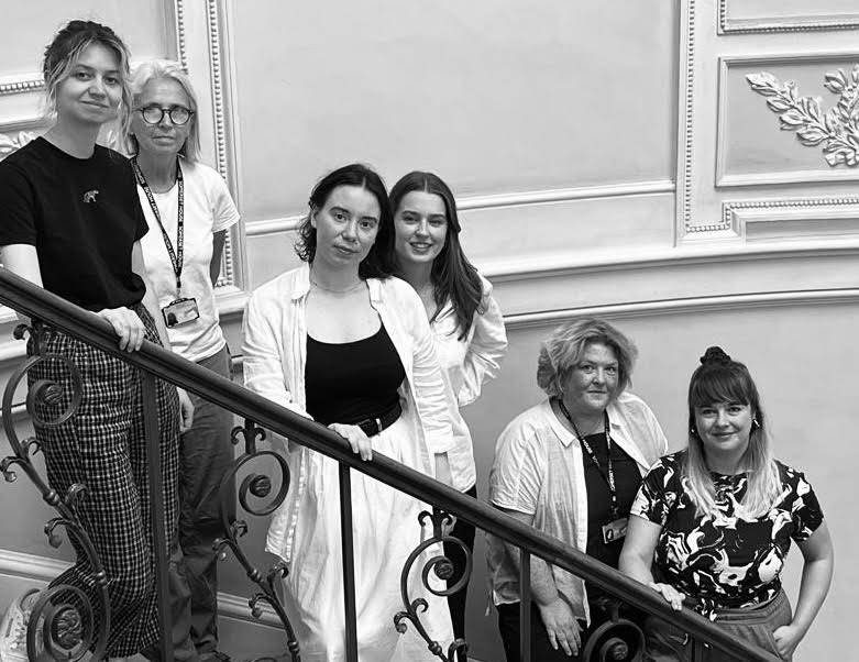 Some members of the Clore team informal black and white portrait on a staircase