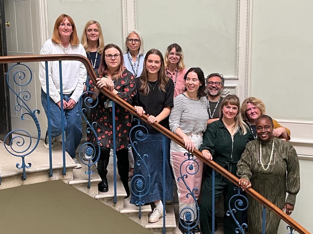 Clore Leadership staff grouped together on an ornate staircase in Somerset House.