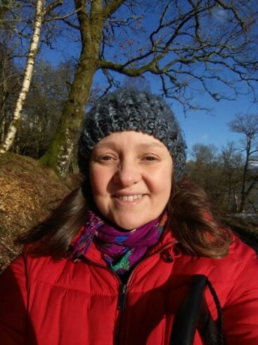 A headshot of Kirsten Luckins, she is outside wearing a re coat and black bobble hat