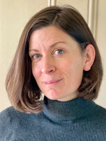 Colour headshot of Claire Antrobus, with short brown hair and wearing a blue jumper