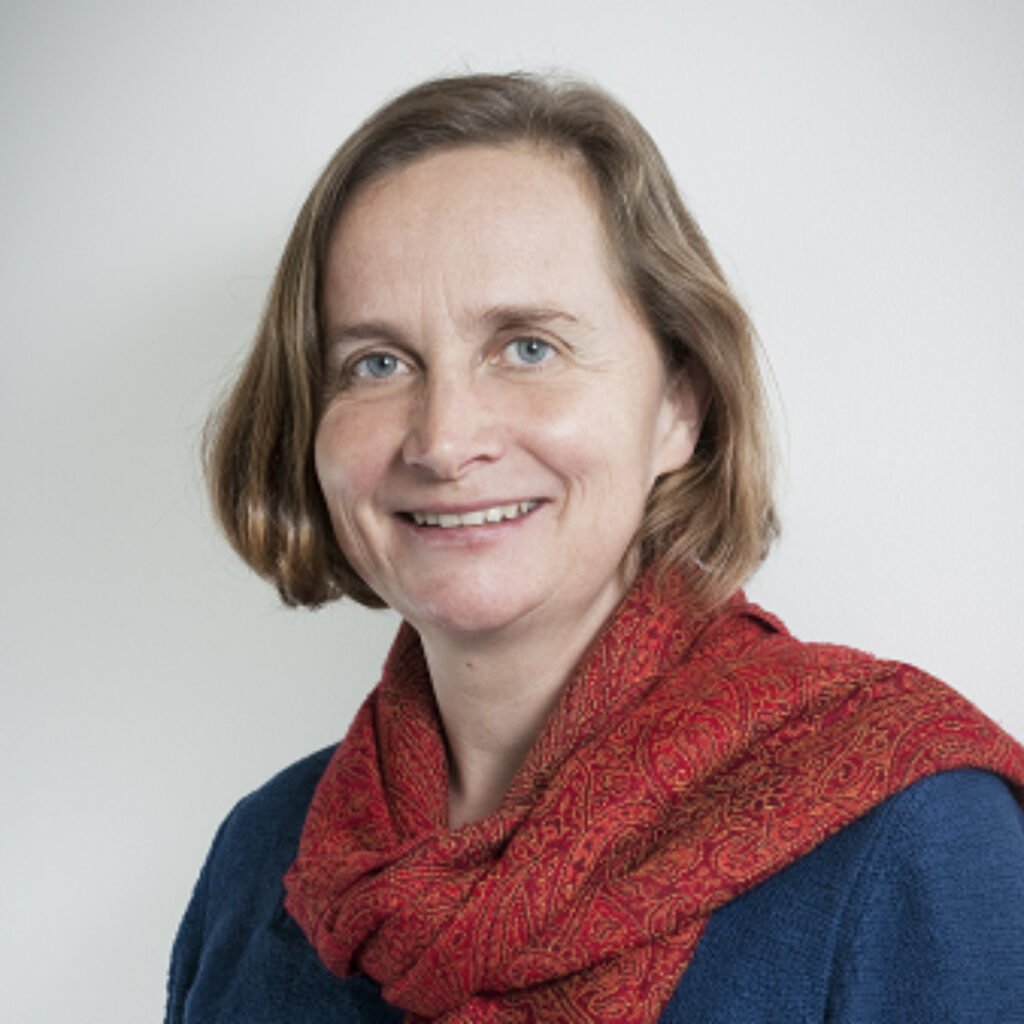 Headshot of Charlotte Jones, she is wearing a red scarf and smiling 