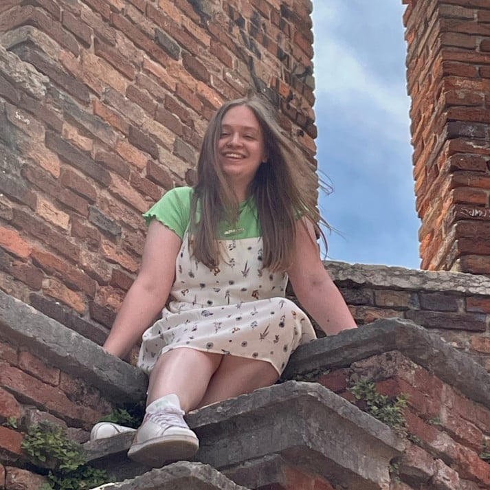 A photo of Beth Ismay sitting on some steps