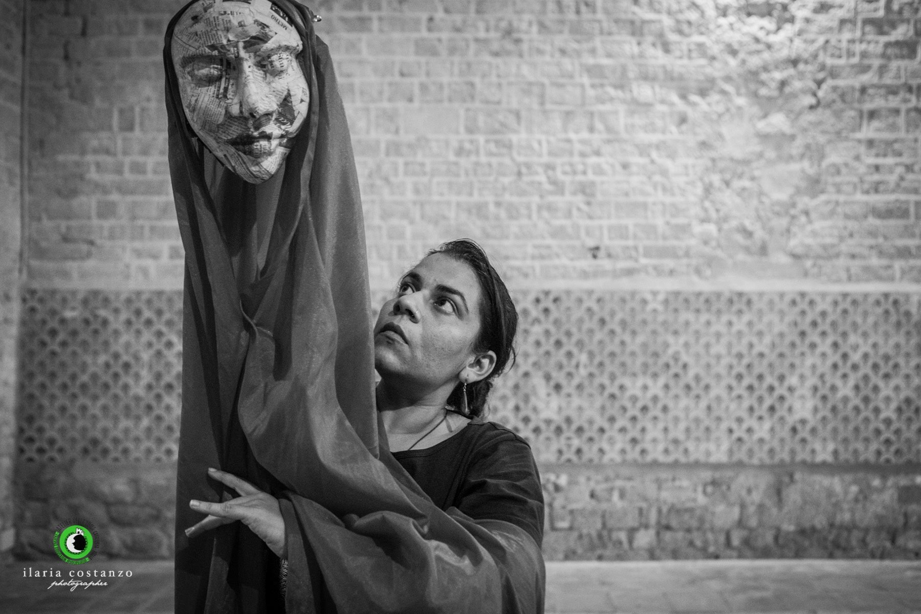 Anurupa skillfully operating a large puppet head made of paper mache newspaper cuttings