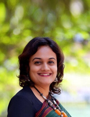 A portrait photograph of Deepti smiling at the camera