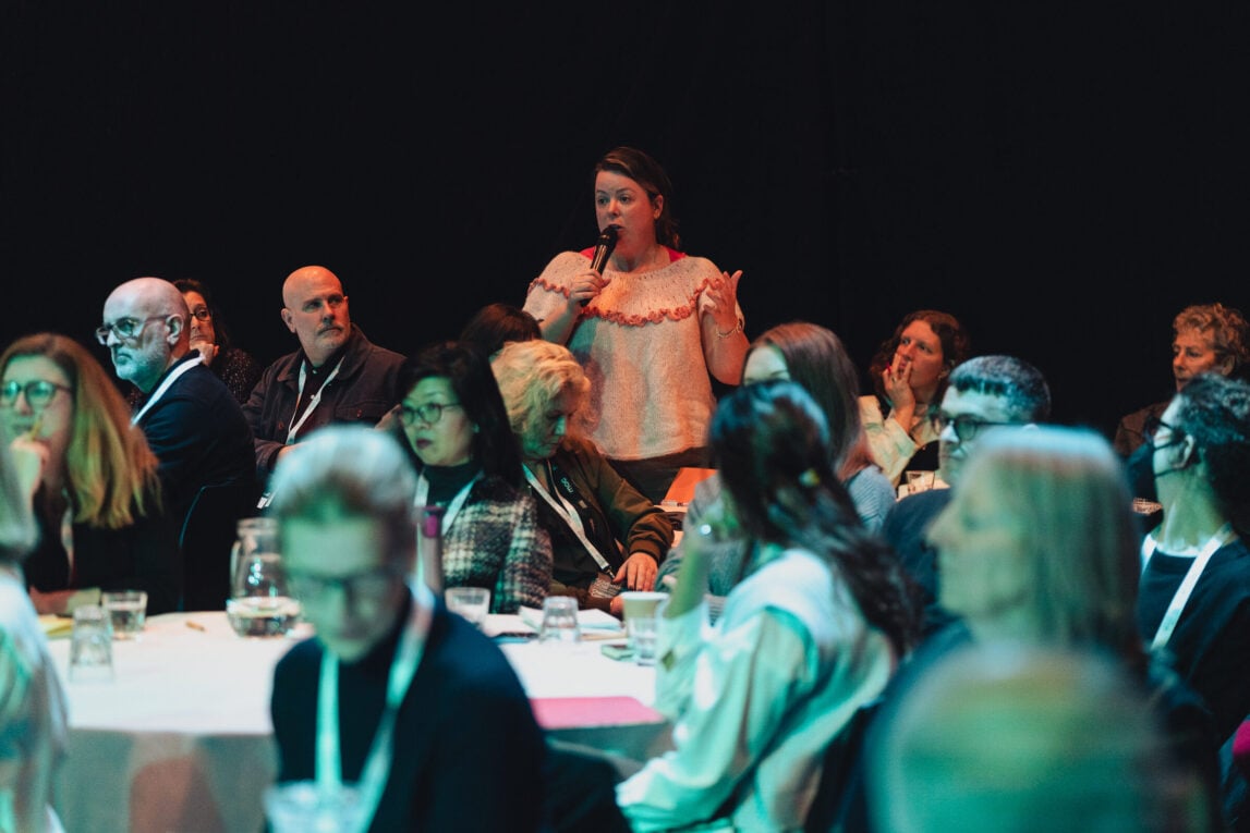 A woman directing a question at the panel at Governance Now 2023